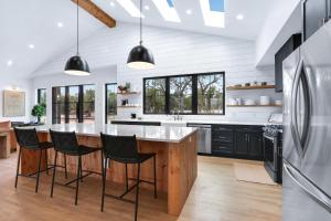 una cucina con una grande isola con sgabelli da bar di Pasatiempos a Wimberley