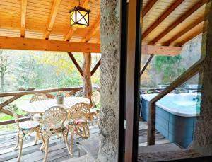 a patio with a table and chairs on a deck at Castrum Houses - Casa da Curveirinha - Jacuzzi in Melgaço