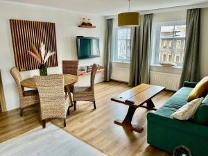 sala de estar con mesa y sofá verde en W parku przy teatrze, en Szczawno-Zdrój
