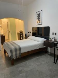 a bedroom with a large bed and a table at La Casa Mia Leon in León