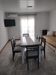 ein Esszimmer mit Tisch und Stühlen und einem Bett in der Unterkunft Lodge Araucaria Apartamento por día in Eduardo Castex