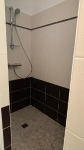 y baño con ducha y azulejos blancos y negros. en Heol, en Saint-Igneuc 9 fotos más