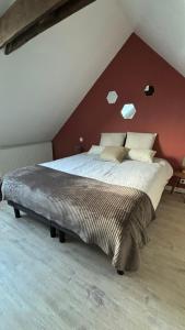 Un dormitorio con una cama grande con una pared roja. en Heol, en Saint-Igneuc