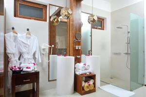 a bathroom with a walk in shower and a shower stall at Tulia Zanzibar Unique Beach Resort in Pongwe