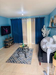 a living room with blue walls and a fan at Chelsea Bliss in Kingston