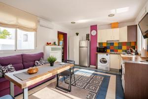 a kitchen and living room with a purple couch at Ático la Azotea con terraza PRIVADA in Seville