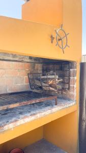 pared de ladrillo con estante y estufa de madera en El Bonito Hostel, en Cabo Polonio