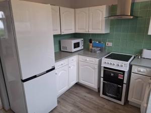 a kitchen with white appliances and a white refrigerator at Kilvington Crib in Sheffield