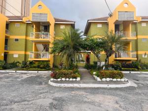 a building with palm trees and flowers in a parking lot at Chelsea Bliss in Kingston