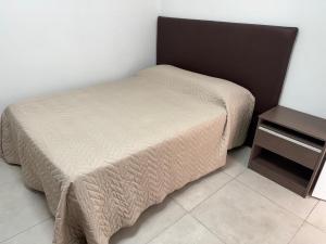 Cama pequeña en habitación con mesa en Departamento en alquiler temporario, en Fernández