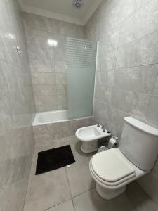 Un baño con inodoro, lavabo y bañera. en Departamento en alquiler temporario, en Fernández