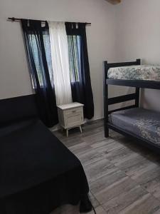 a bedroom with two bunk beds and a small table at cabañas Saona in Molinari