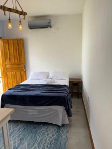 a bedroom with a bed and a wooden door at Vila Mar Studio in Imbituba