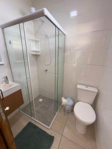 a bathroom with a shower and a toilet and a sink at Vila Mar Studio in Imbituba +7 photos