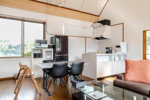 a kitchen and living room with a table and chairs at -Shiratec Premium by Base- スイート仕様の貸切ハウス,広い庭を独り占め in Onna