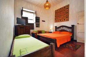 a bedroom with two beds and a flat screen tv at Casa Ruta Sur in Cali