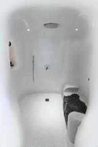 a white room with a bed in the middle at Maregio Suites in Oia