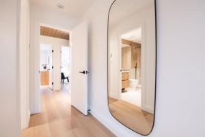 um espelho num quarto branco com um corredor em Forest Trails by Outpost Whistler em Whistler