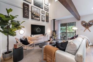 uma sala de estar com um sofá e uma TV em Forest Trails by Outpost Whistler em Whistler