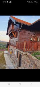 a wooden house with a balcony on the side of it at MareBob in Peršaves