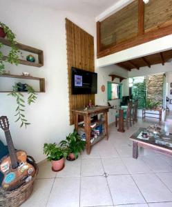 uma sala de estar com uma mesa e uma TV na parede em Samauma Floripa Aluguel de Quartos em Florianópolis