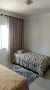 a bedroom with two beds and a window at Apto vista mar in Balneário Camboriú