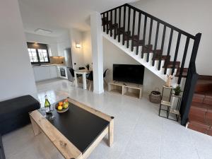 a living room with a table and a staircase at Beach Dúplex Costa Teguise in Costa Teguise