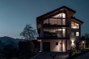 a modern house with a balcony at night at Bfour in Pergine Valsugana
