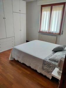 a bedroom with a large bed and white cabinets at Casa a Villa in Perugia