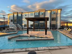 a large swimming pool with a building in the background at New Resort Condo Near Zion Great for Families Pools Water Slide in Hurricane
