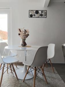 Un comedor blanco con una mesa y sillas blancas. en Aconchego Alojamento Local, en Nazaré