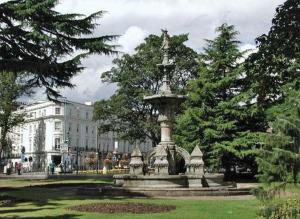 a fountain in a park in front of a building at New Stylish 4-Bed-WiFi-Free Parking in Leamington Spa