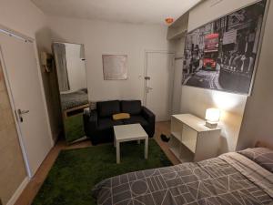 a bedroom with a bed and a couch and a chair at Lovely studio flat in Hackney Clapton in London