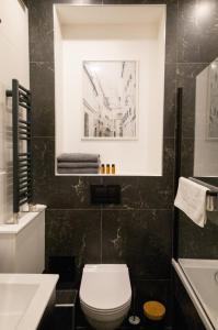 a bathroom with a toilet and a sink at Galeria Italiana Apartments in Wrocław +104 photos
