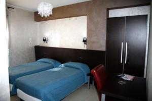 a bedroom with two beds and a mirror at Hotel Miramonti in Gangi