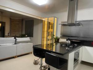 a kitchen and living room with a counter and a couch at Casa da Mariah in Arroio do Meio
