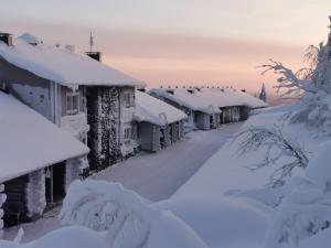 a row of houses covered in snow at Pöllönpesä Iso-Syöte in Syöte