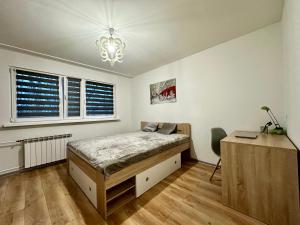 sypialnia z łóżkiem, biurkiem i oknem w obiekcie Apartament Wieluńska w Warszawie