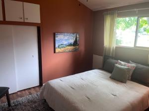a bedroom with a bed and a painting on the wall at Treehouse in Rainer Beach in Seattle