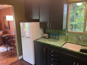 a kitchen with a white refrigerator and a sink at Treehouse in Rainer Beach in Seattle