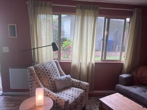 a living room with a chair and a candle on a table at Treehouse in Rainer Beach in Seattle