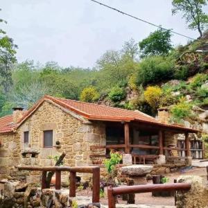 a stone house in front of a mountain at Aldeia de Pontes - Castro Laboreiro in Castro Laboreiro