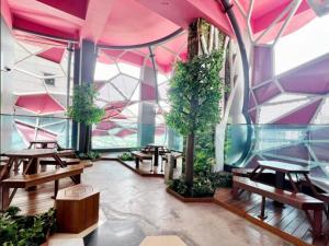 a room with tables and trees and a pink ceiling at ARTEplus JALAN AMPANG KLCC in Kuala Lumpur