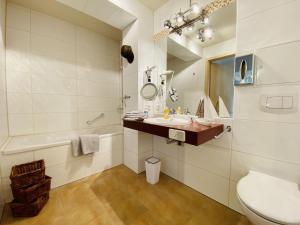 a bathroom with a sink and a toilet and a tub at Ferienwohnung Weltenbummler Haus Strandbummler Baabe in Baabe +21 photos