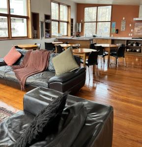 un soggiorno con divano, tavoli e sedie di On Top Backpackers a Dunedin