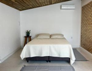 a bedroom with a bed in a white room at Guarda do Embaú Aluguél Casa 300mts Praia in Guarda do Embaú +32 photos