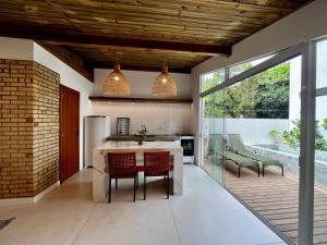an open kitchen with a dining table and chairs at Guarda do Embaú Aluguél Casa 300mts Praia in Guarda do Embaú