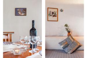 a bottle of wine sitting on a table with wine glasses at Karavos Sea View Apartments in Skopelos Town