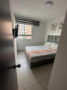 a small bedroom with a bed and a window at apartamento amoblado en la clinica internacional,ALQUILER RENTA HOUSE in Floridablanca