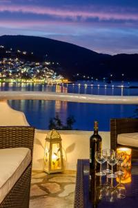 a table with wine glasses and a bottle of wine at Karavos Sea View Apartments in Skopelos Town